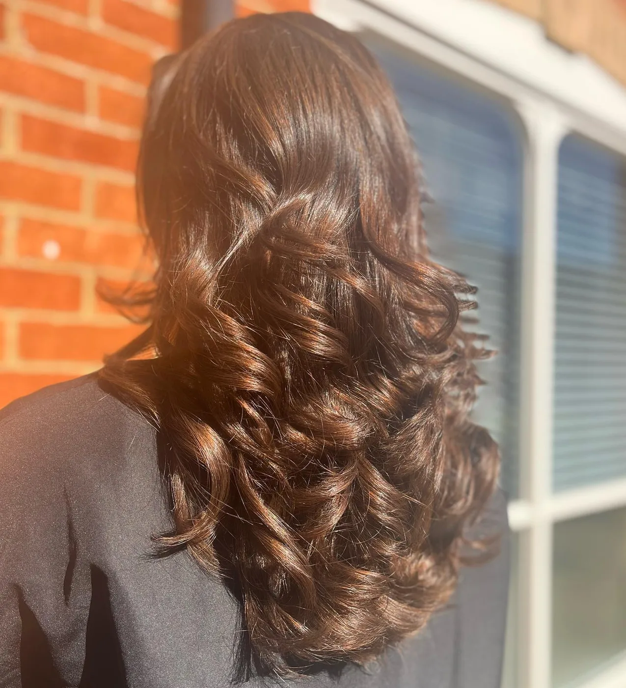 Glossy brunette curls in sunlight